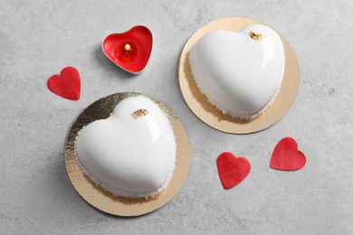 St. Valentine's Day. Delicious heart shaped cakes, candle and confetti on light table, flat lay
