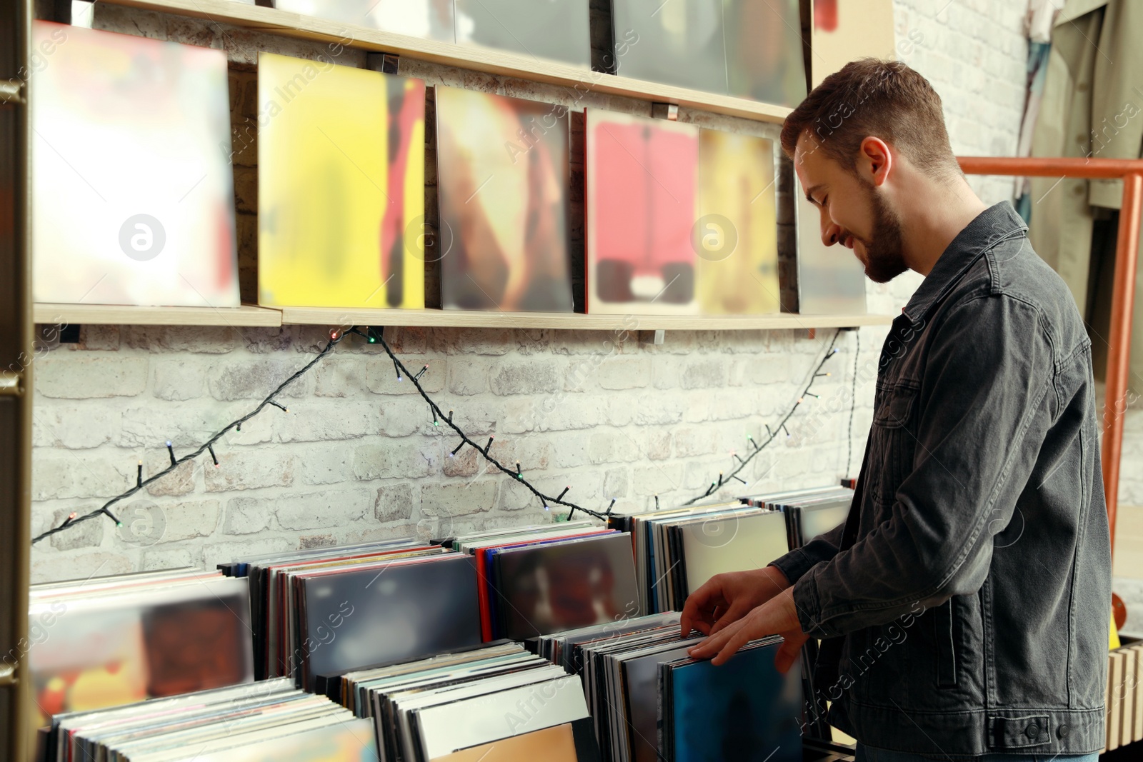 Image of Young man choosing vinyl records in store