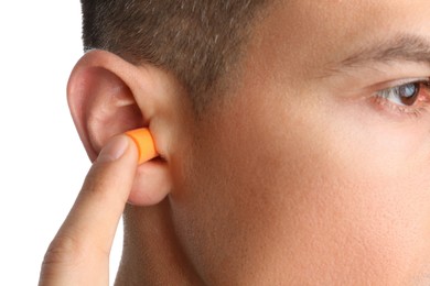 Photo of Man inserting foam ear plug on white background, closeup