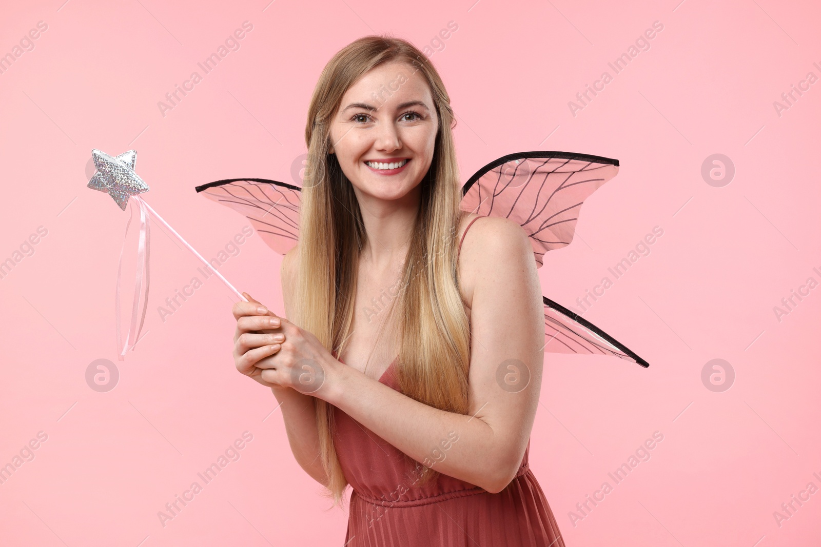 Photo of Beautiful girl in fairy costume with wings on pink background