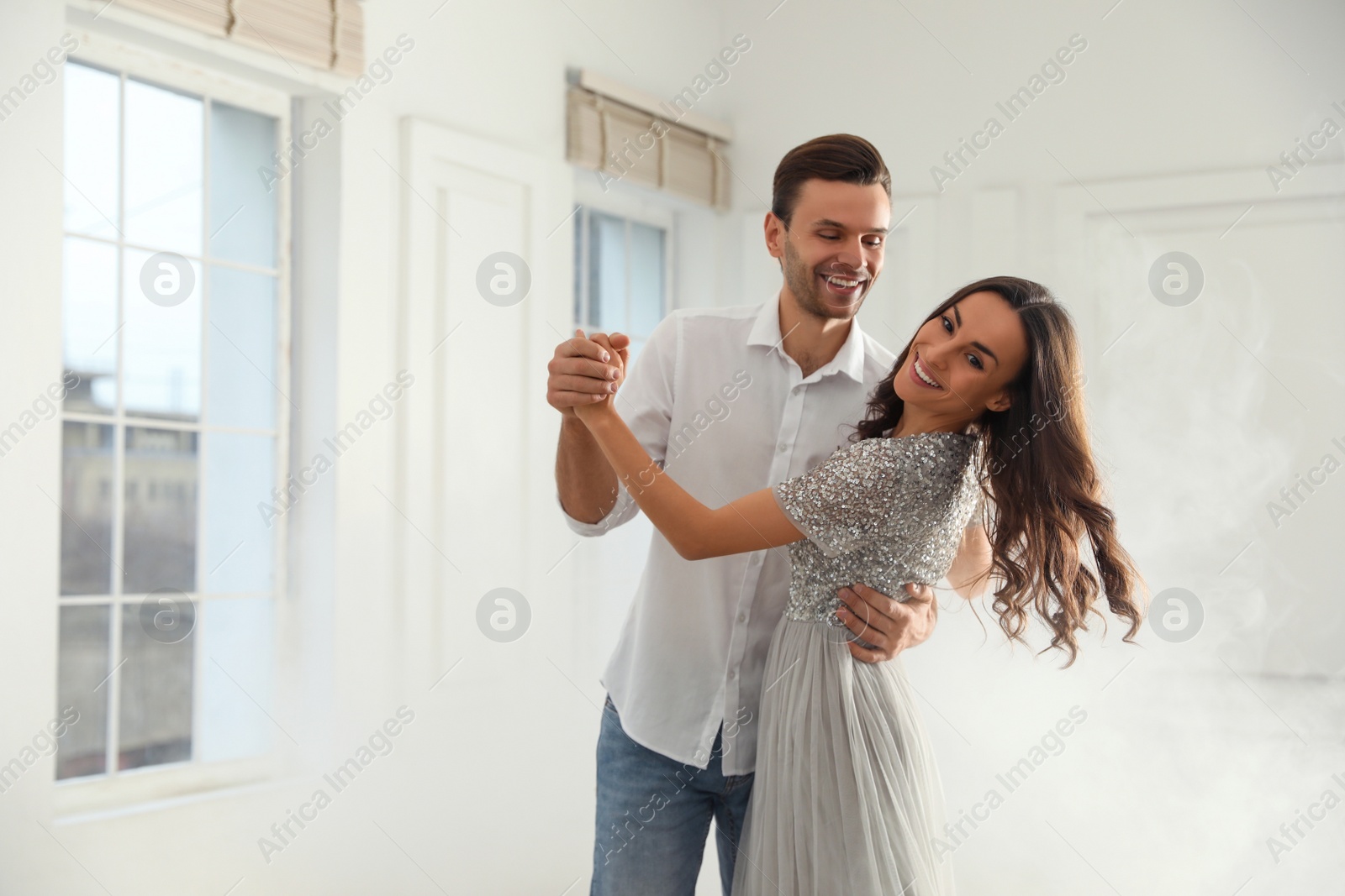 Photo of Lovely young couple dancing together in ballroom. Space for text