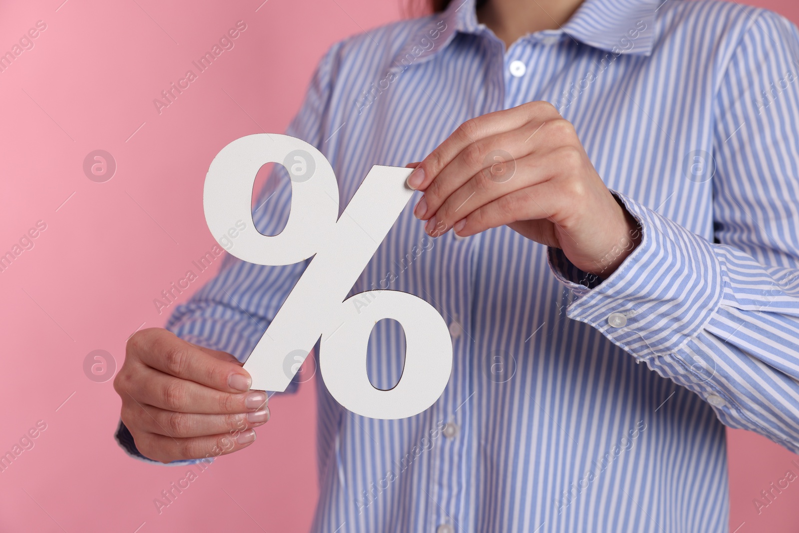 Photo of Woman holding percent sign on pink background, closeup