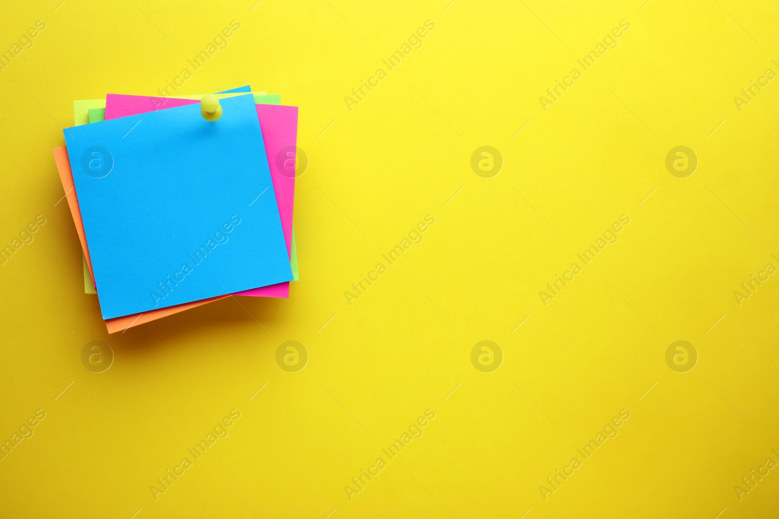 Photo of Paper notes on yellow background, top view. Space for text