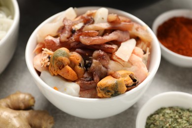 Seafood and spices for cooking wok on grey table, closeup