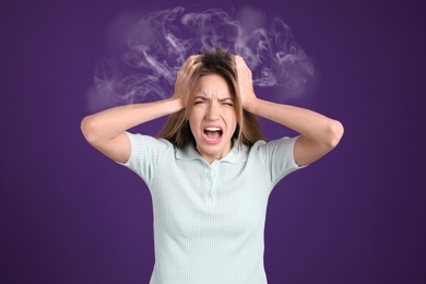 Image of Stressed and upset young woman on violet background