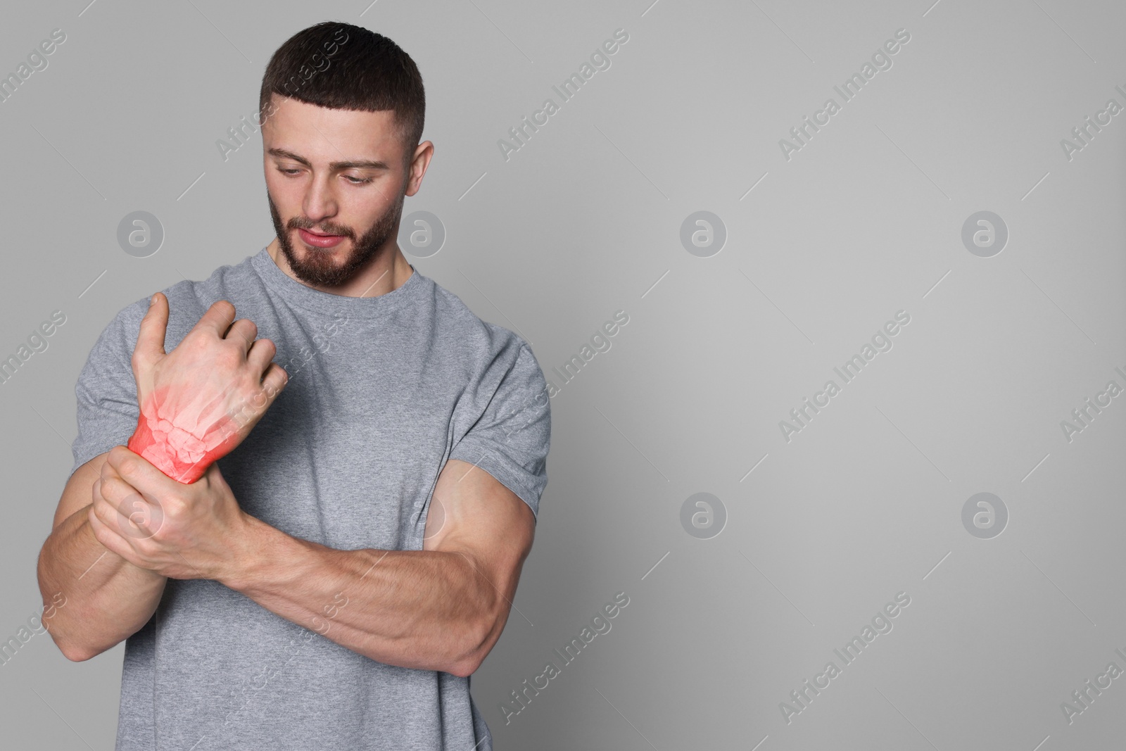 Image of Arthritis symptoms. Man suffering from pain in his wrist on light grey background, space for text