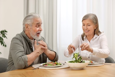 Happy senior couple having dinner at home