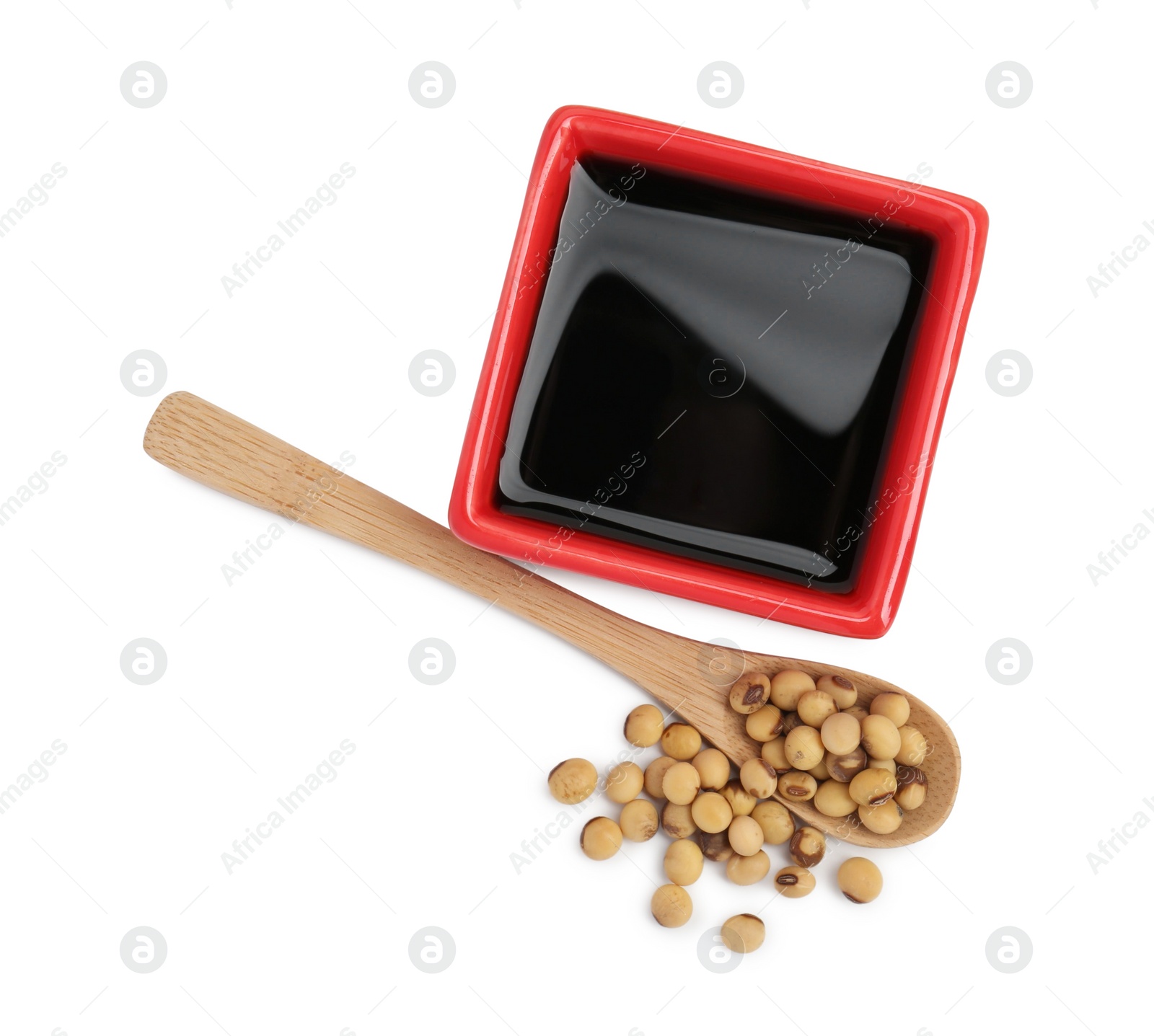 Photo of Tasty soy sauce in bowl, soybeans and spoon isolated on white, top view