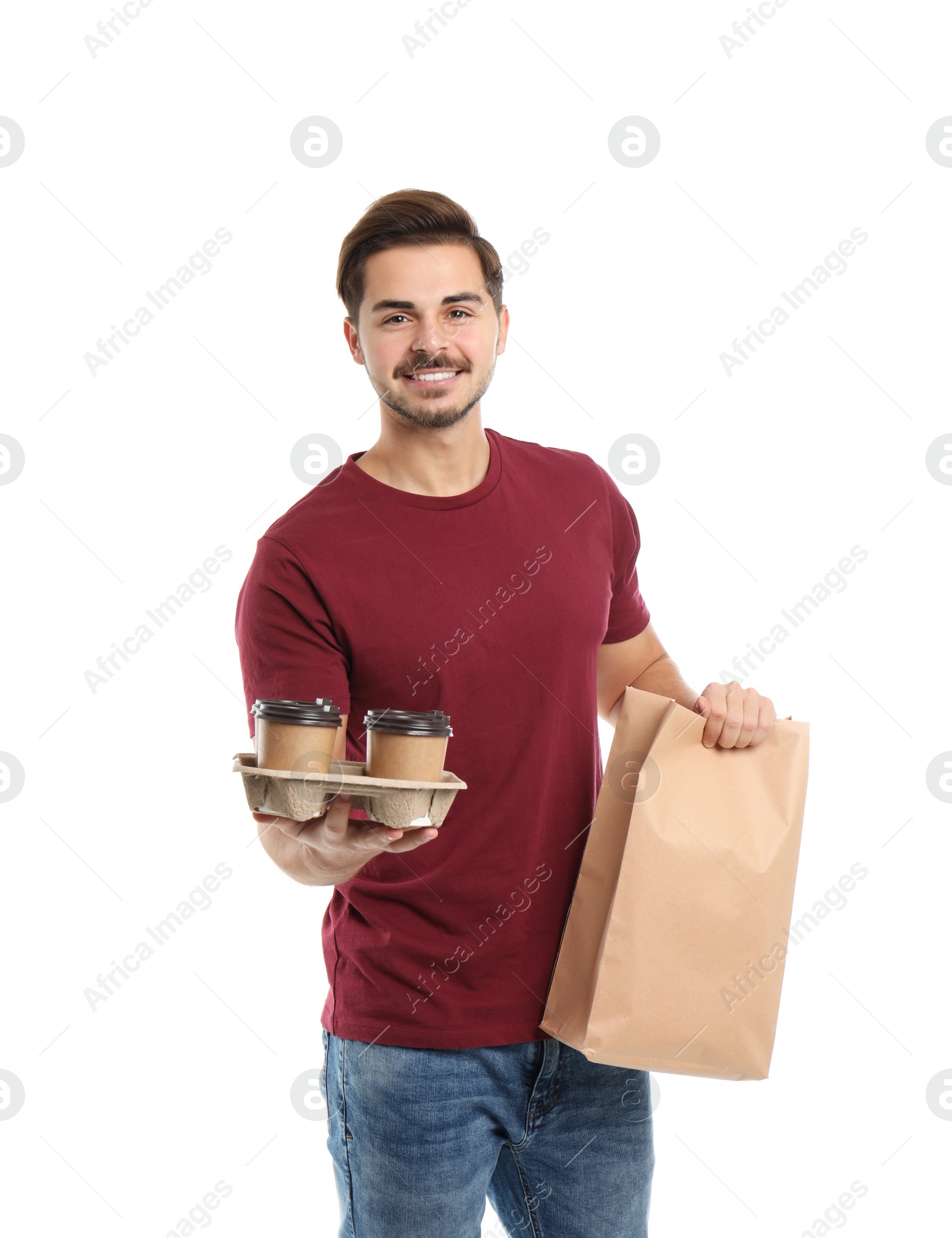 Photo of Young courier with paper bag and drinks on white background. Food delivery service