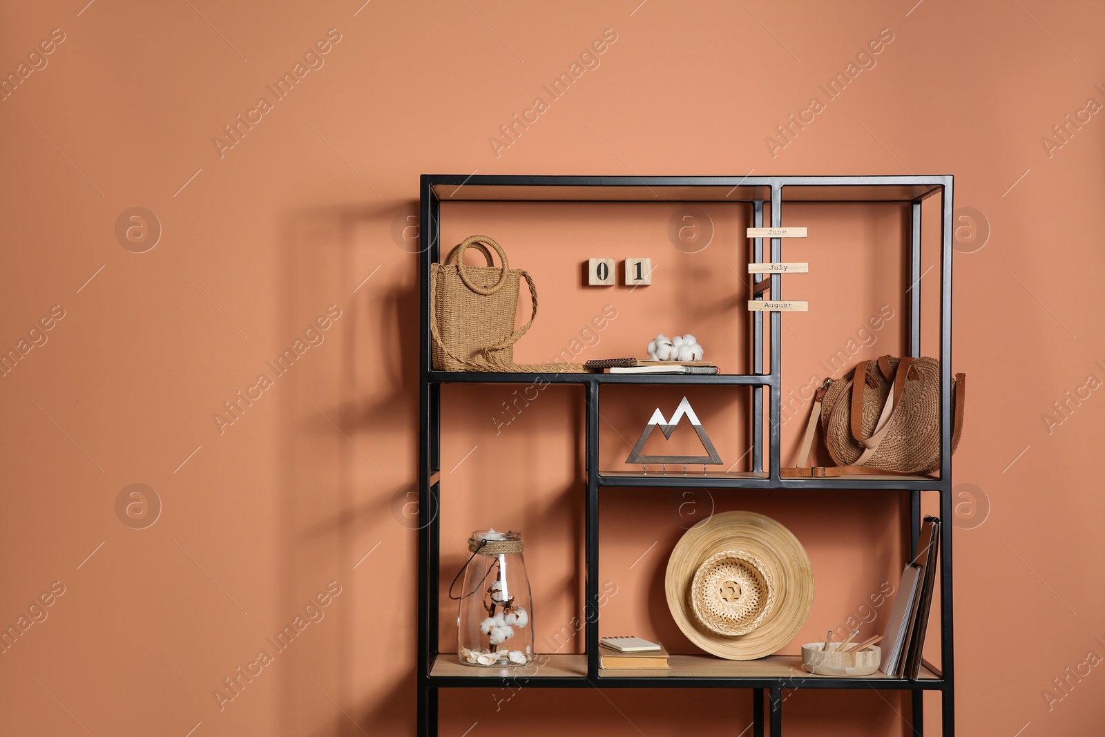 Photo of Stylish shelving unit with decorative elements near color wall. Space for text