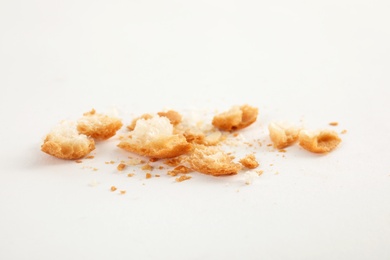 Photo of Scattered bread crumbs on white background, closeup