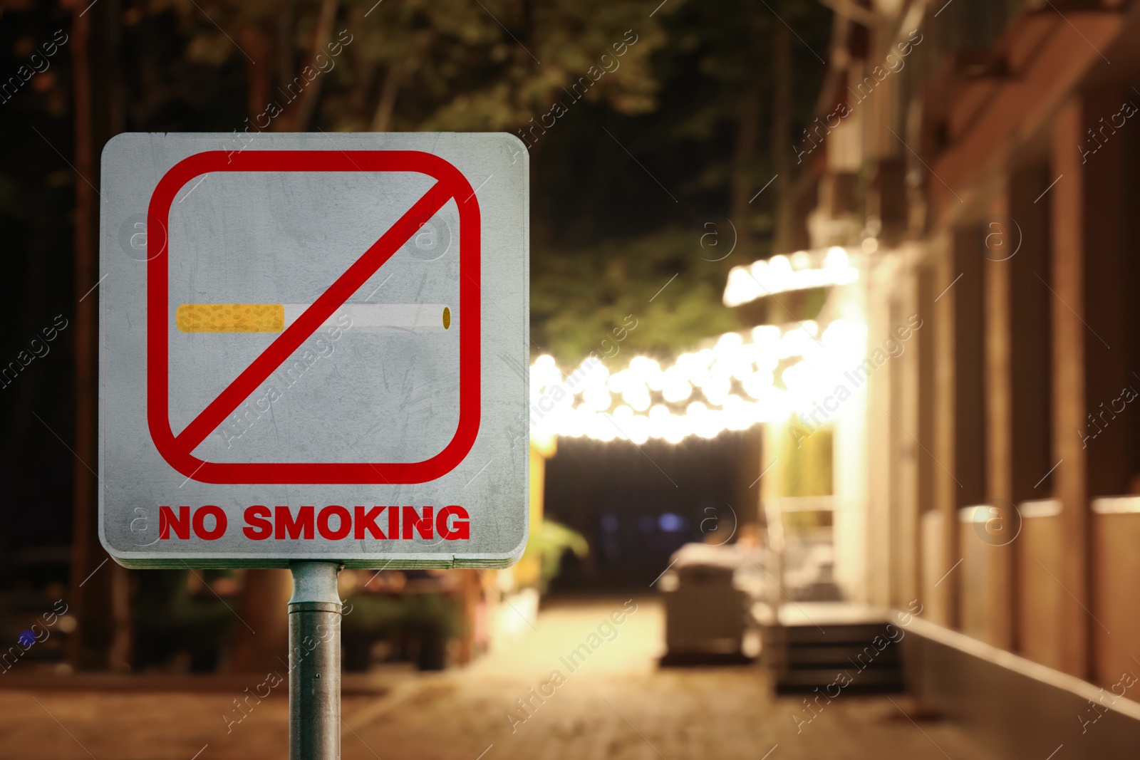 Image of Sign No Smoking on city street in evening, space for text