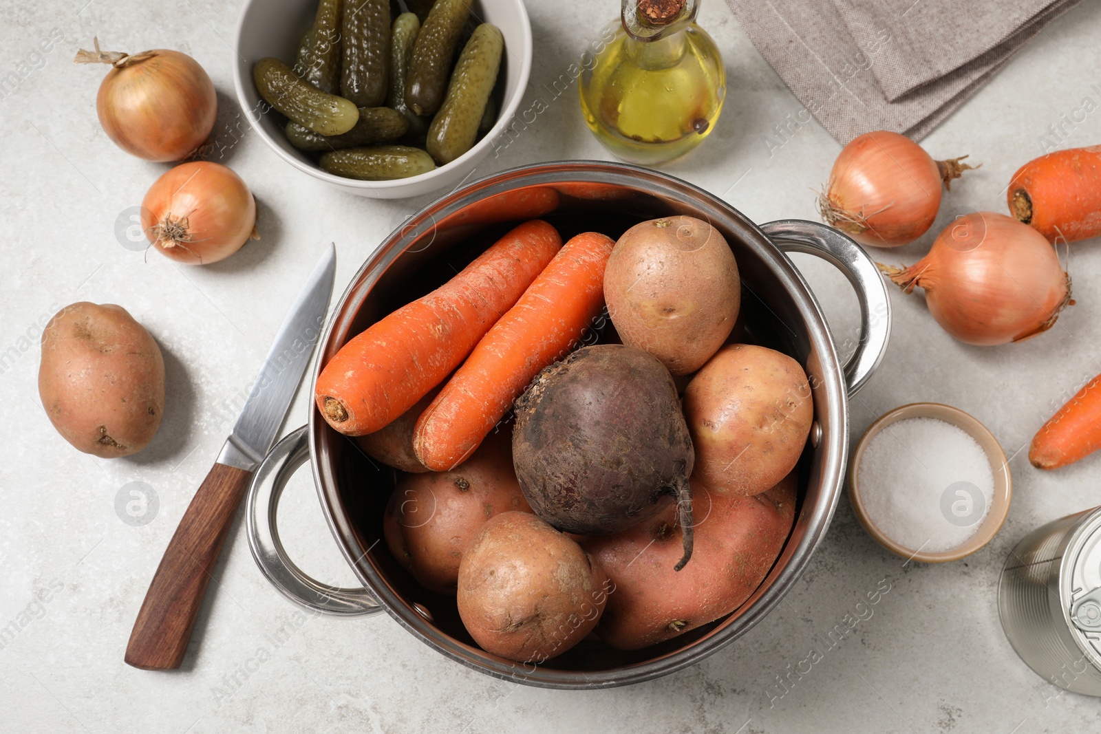 Photo of Many fresh vegetables and other ingredients on white table, flat lay. Cooking vinaigrette salad