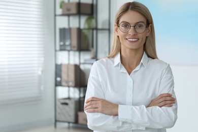 Photo of Portrait of beautiful woman in formal clothes and glasses indoors. Space for text. Confident lady with blonde hair looking into camera