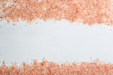 Pink himalayan salt on white wooden table, flat lay. Space for text