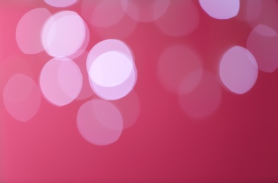 Photo of Blurred view of festive lights on red background. Bokeh effect