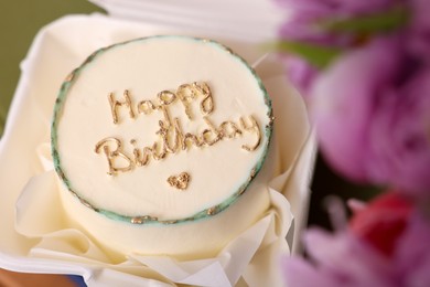 Photo of Delicious decorated Birthday cake and beautiful flowers indoors, closeup