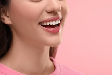 Woman with clean teeth smiling on pink background, closeup. Space for text