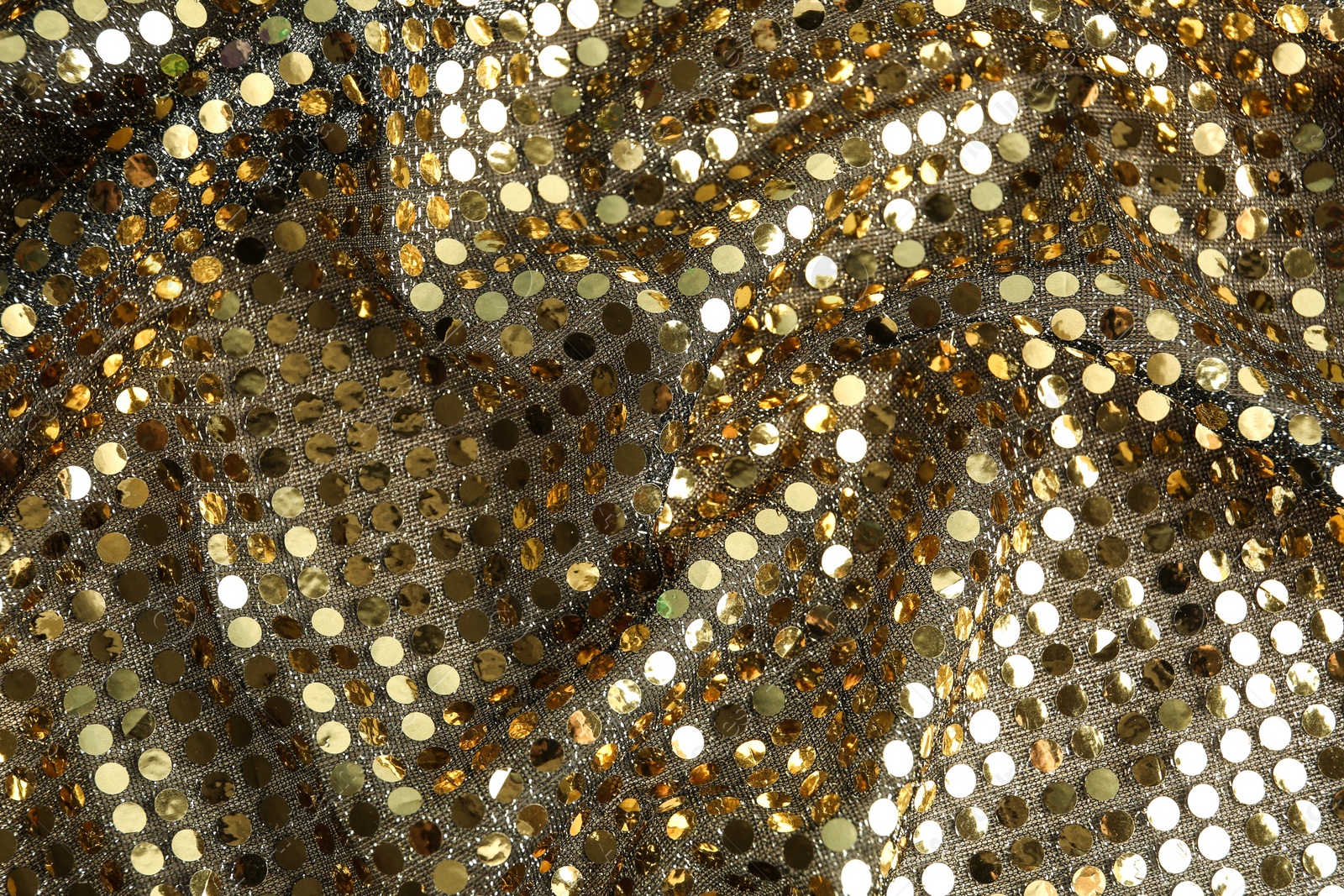 Photo of Texture of beautiful golden fabric with paillettes as background, closeup