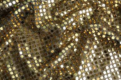 Photo of Texture of beautiful golden fabric with paillettes as background, closeup