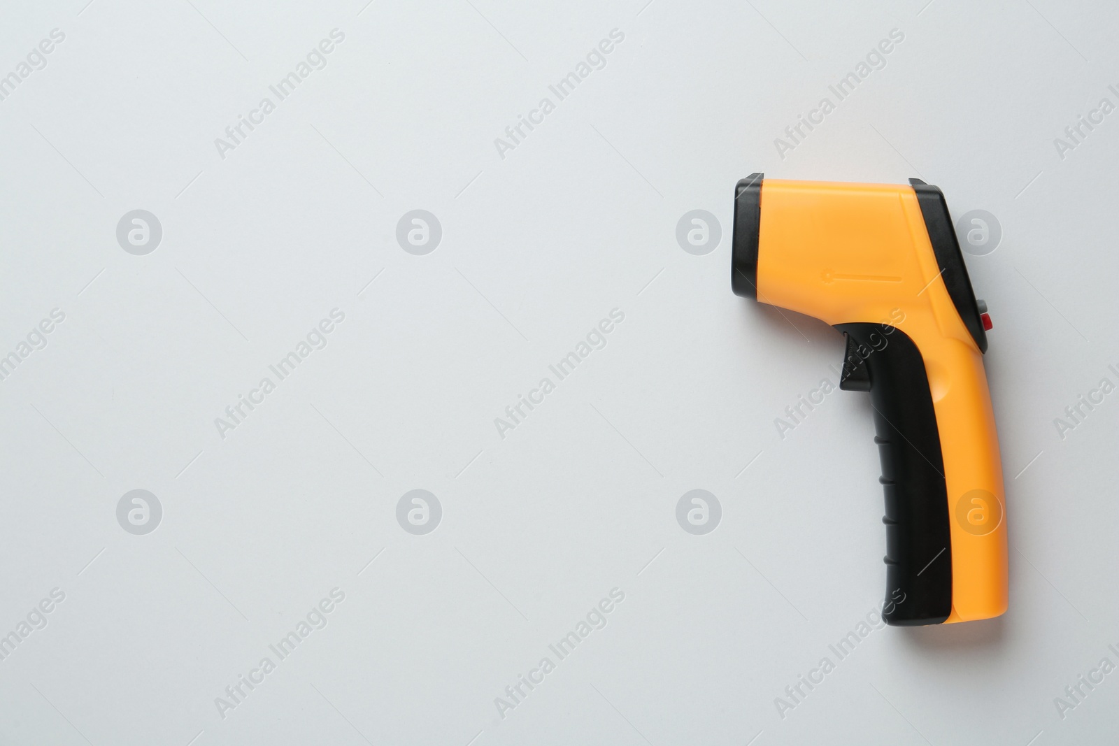 Photo of Infrared thermometer on grey background, top view with space for text. Checking temperature during Covid-19 pandemic