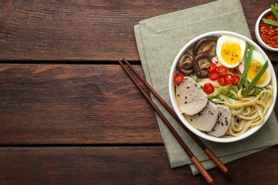 Photo of Delicious ramen with meat in bowl served on wooden table, flat lay. Space for text. Noodle soup