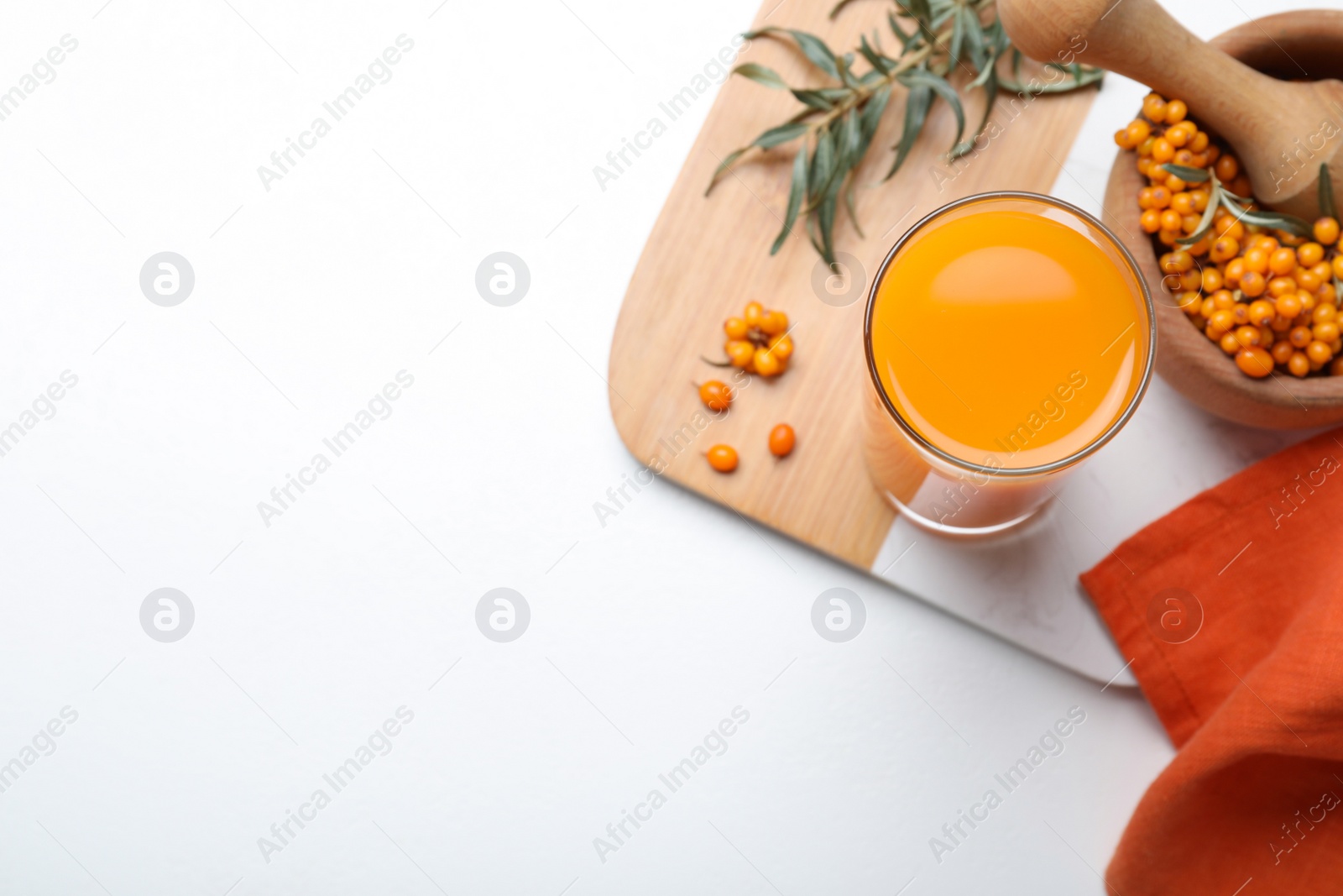 Photo of Top view of sea buckthorn juice on white table, space for text