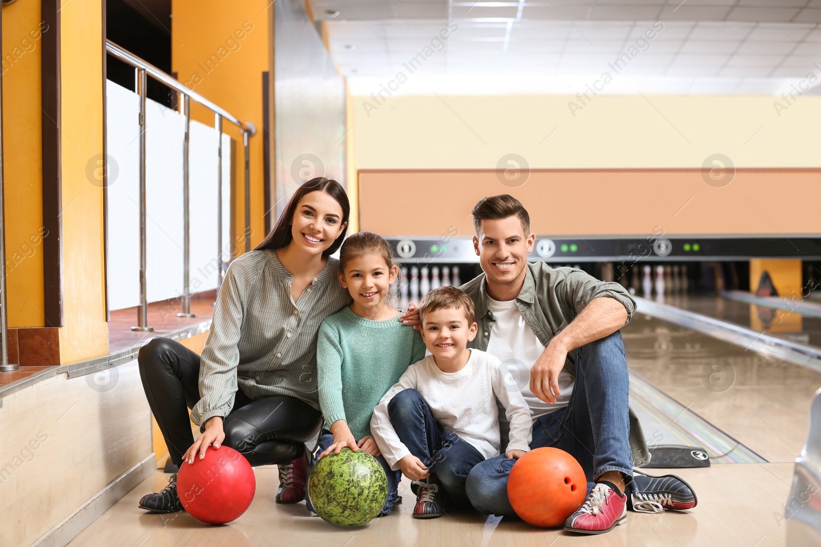 Photo of Happy family spending time together in bowling club