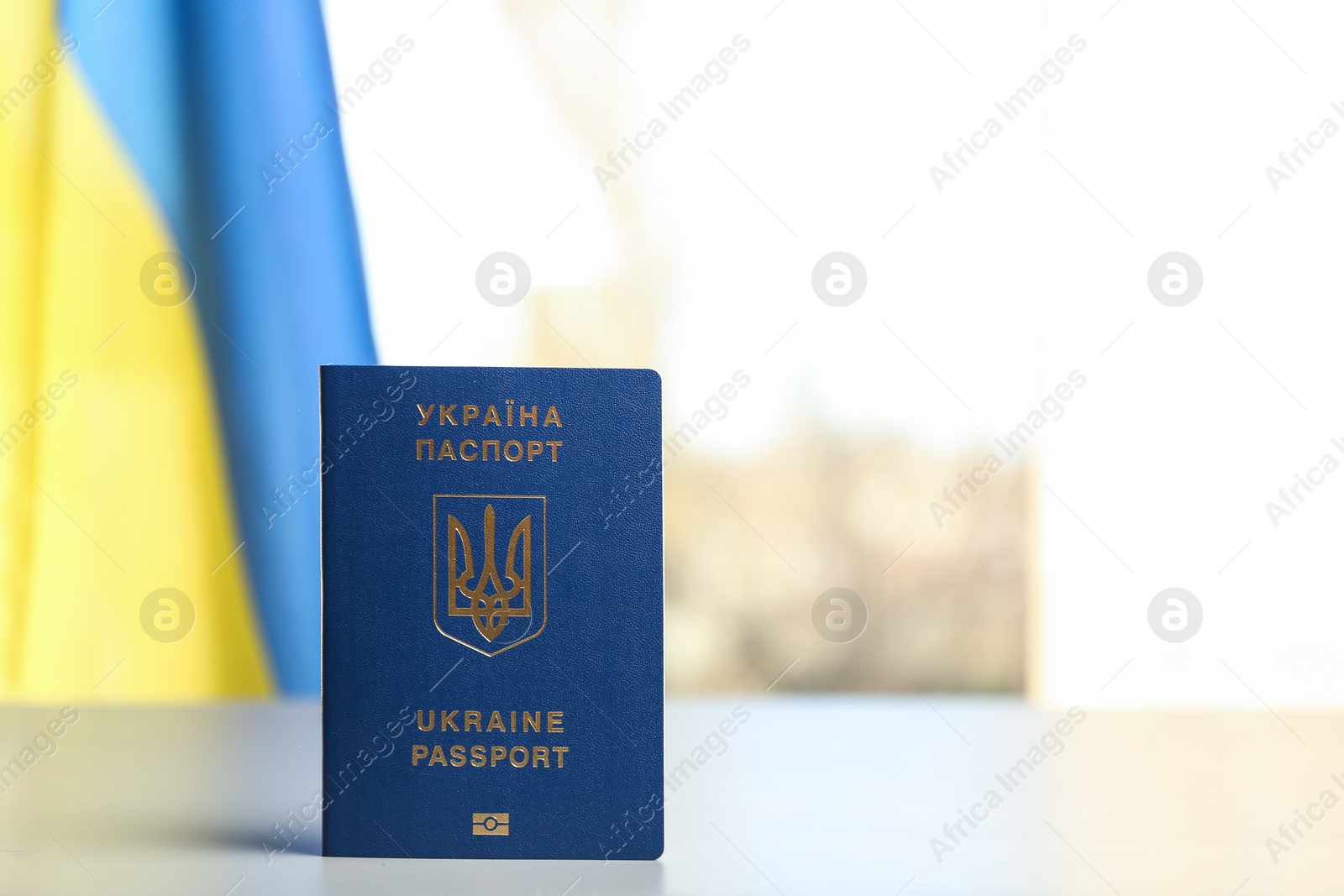 Photo of Ukrainian travel passport on table against blurred background, space for text. International relationships