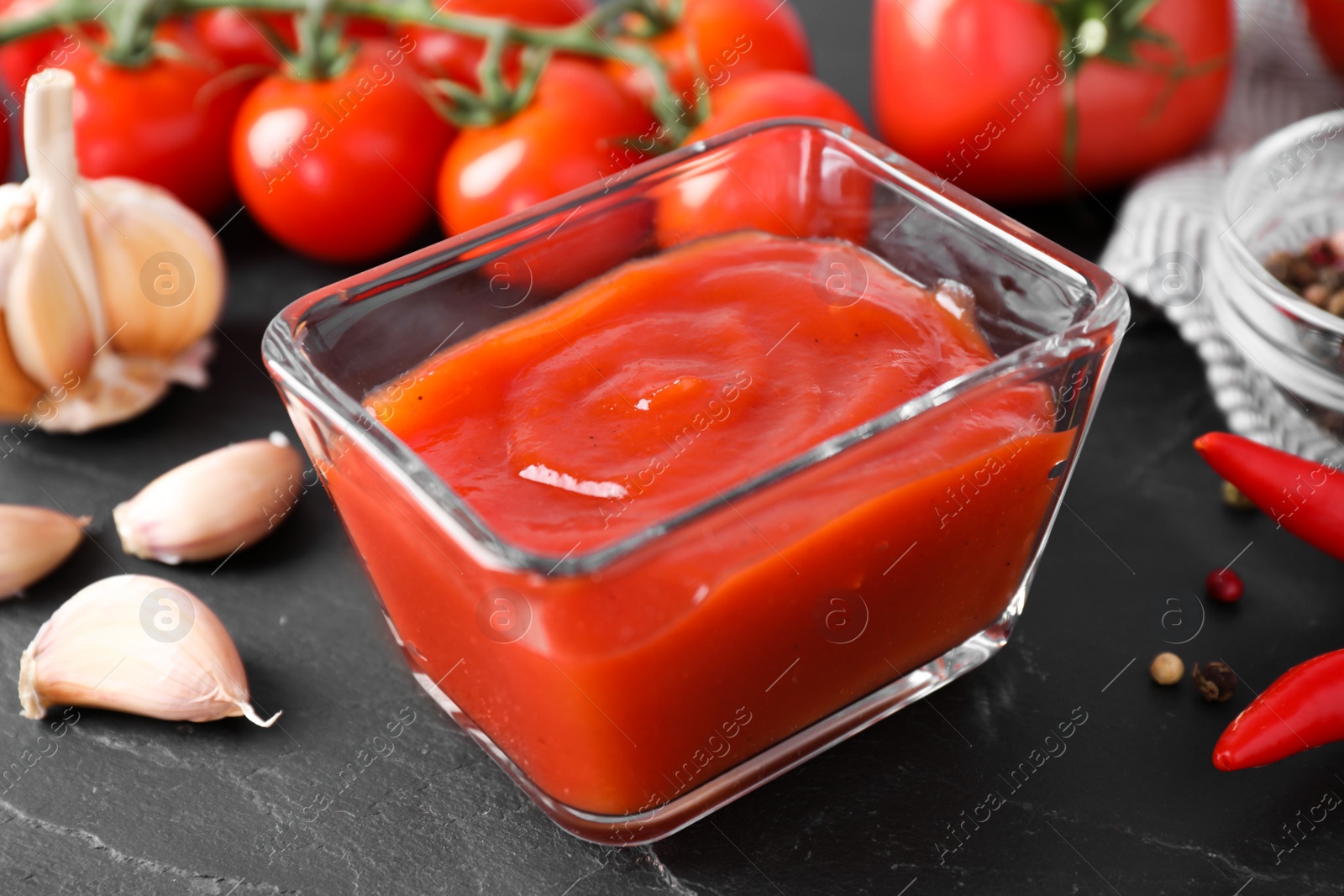 Photo of Delicious fresh tomato sauce on black table, closeup