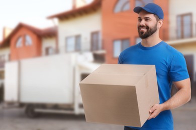 Image of Happy courier with parcel outdoors, space for text