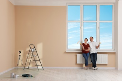 Photo of Happy couple discussing interior details in apartment during repair