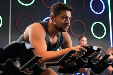 Photo of Man training on exercise bike in fitness club