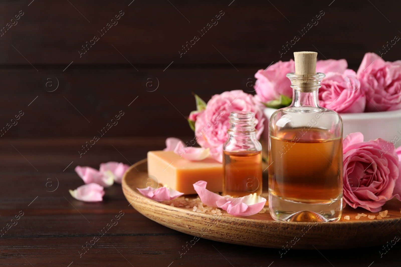 Photo of Composition with aroma oil on wooden table, closeup. Space for text
