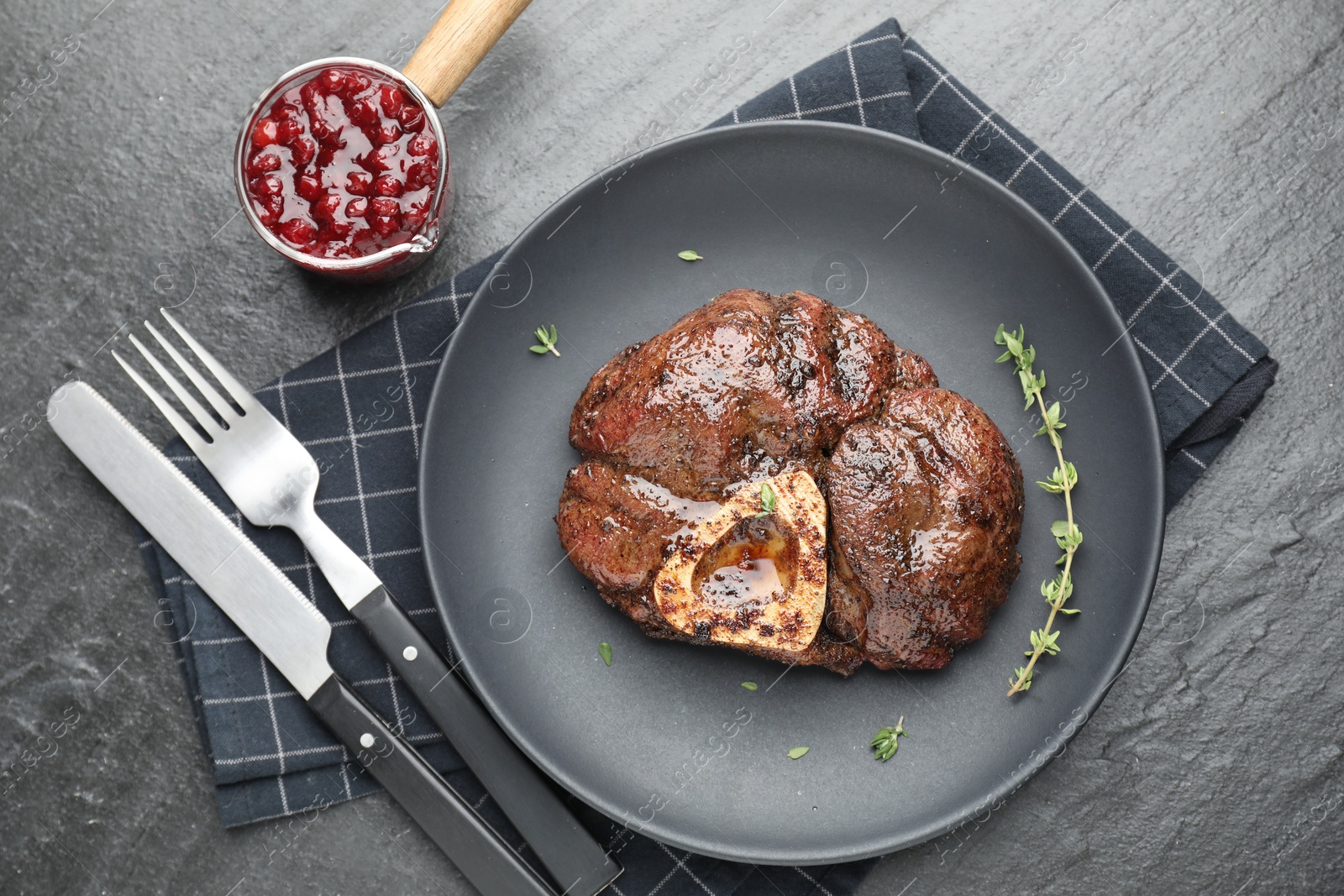 Photo of Delicious roasted beef meat served with sauce on black table, flat lay