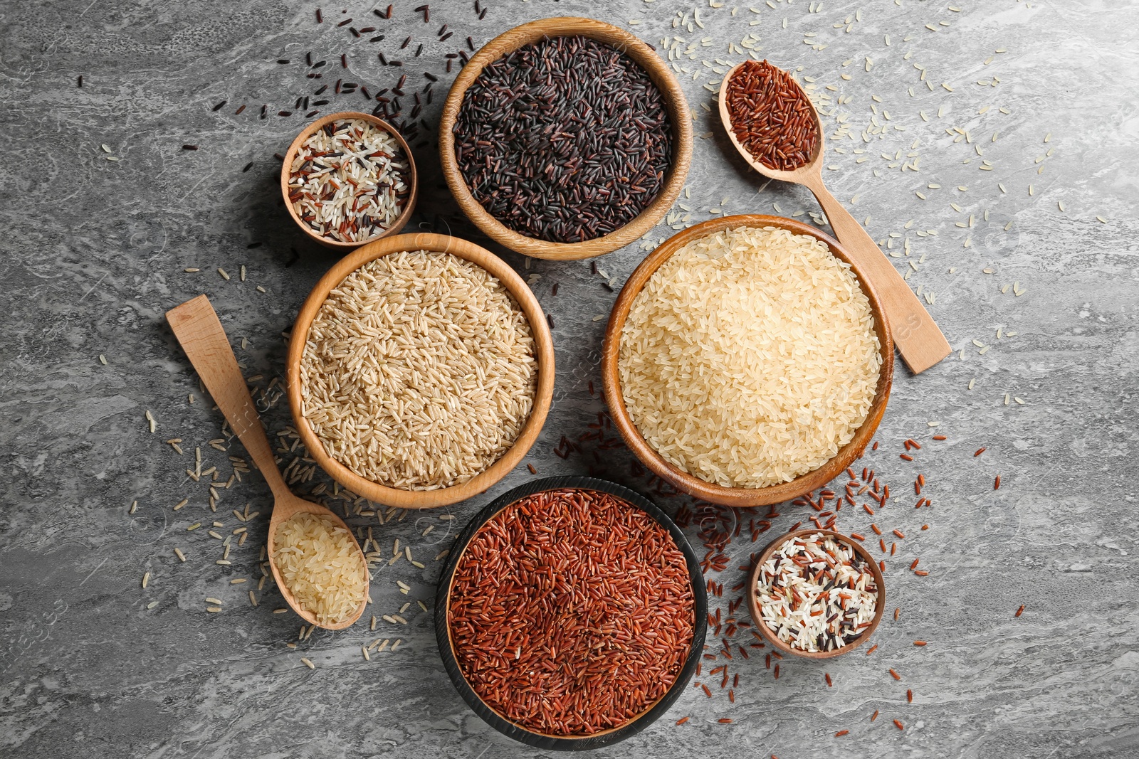 Photo of Flat lay composition with brown and other types of rice on grunge background