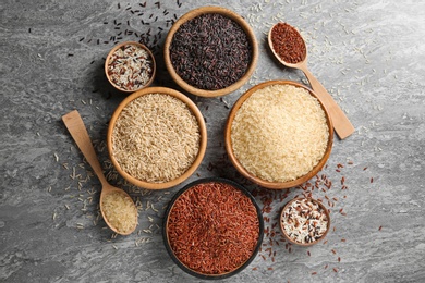 Photo of Flat lay composition with brown and other types of rice on grunge background