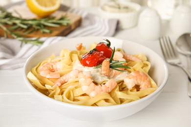 Delicious pasta with shrimps on white wooden table