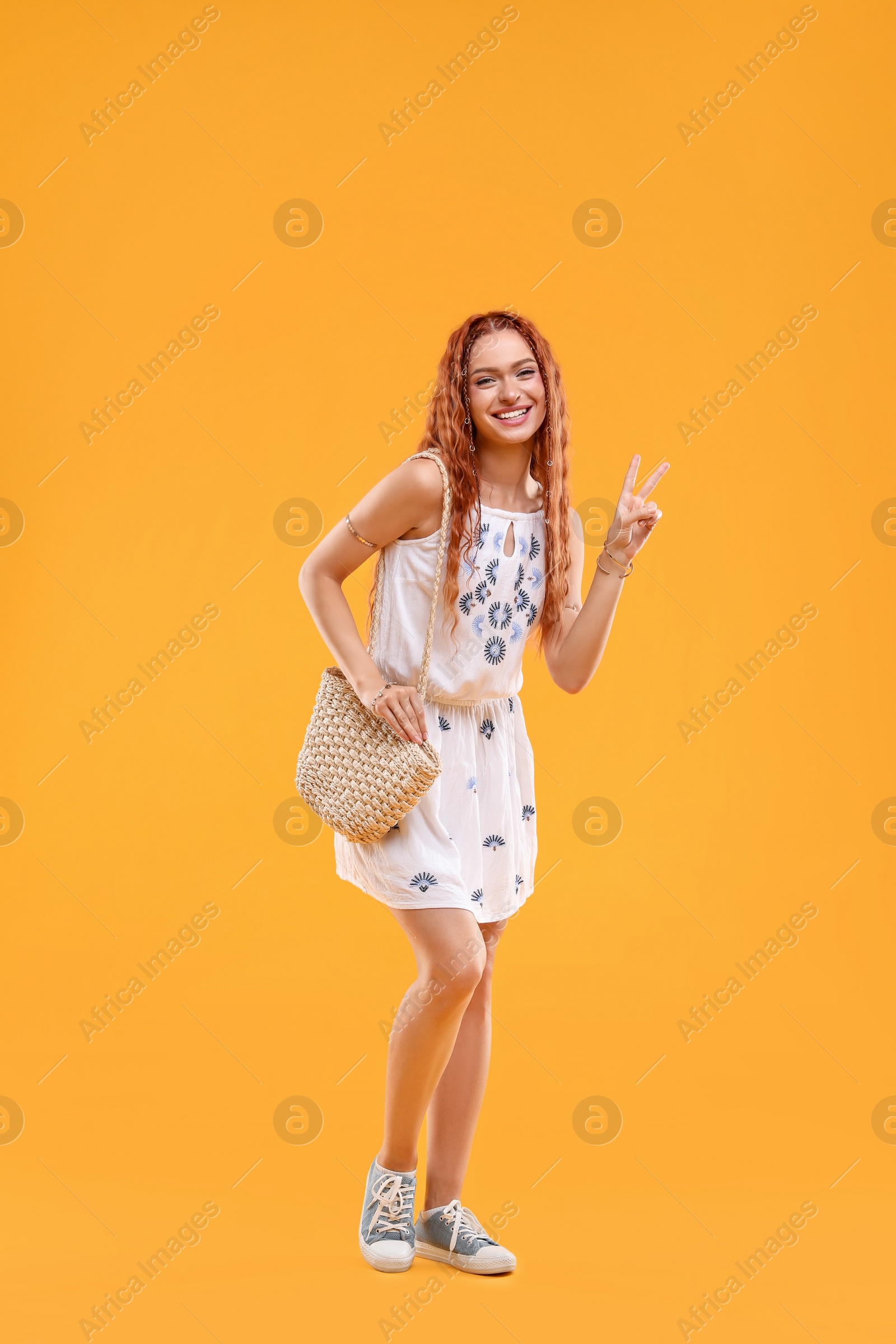 Photo of Beautiful young hippie woman on orange background