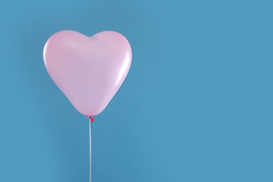 Festive heart shaped balloon on light blue background. Space for text