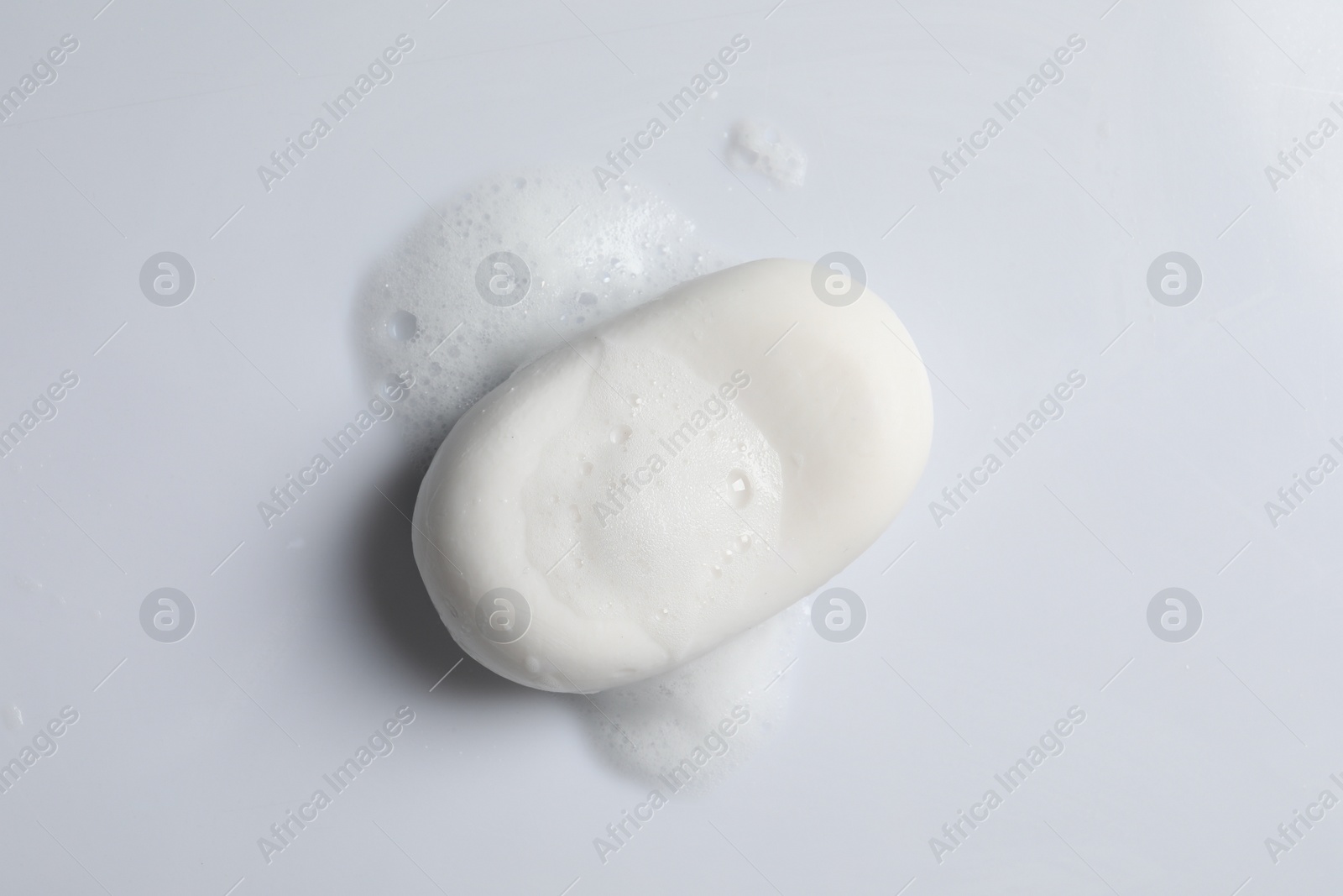 Photo of Soap and fluffy foam on white background, top view
