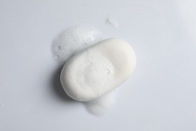 Soap and fluffy foam on white background, top view