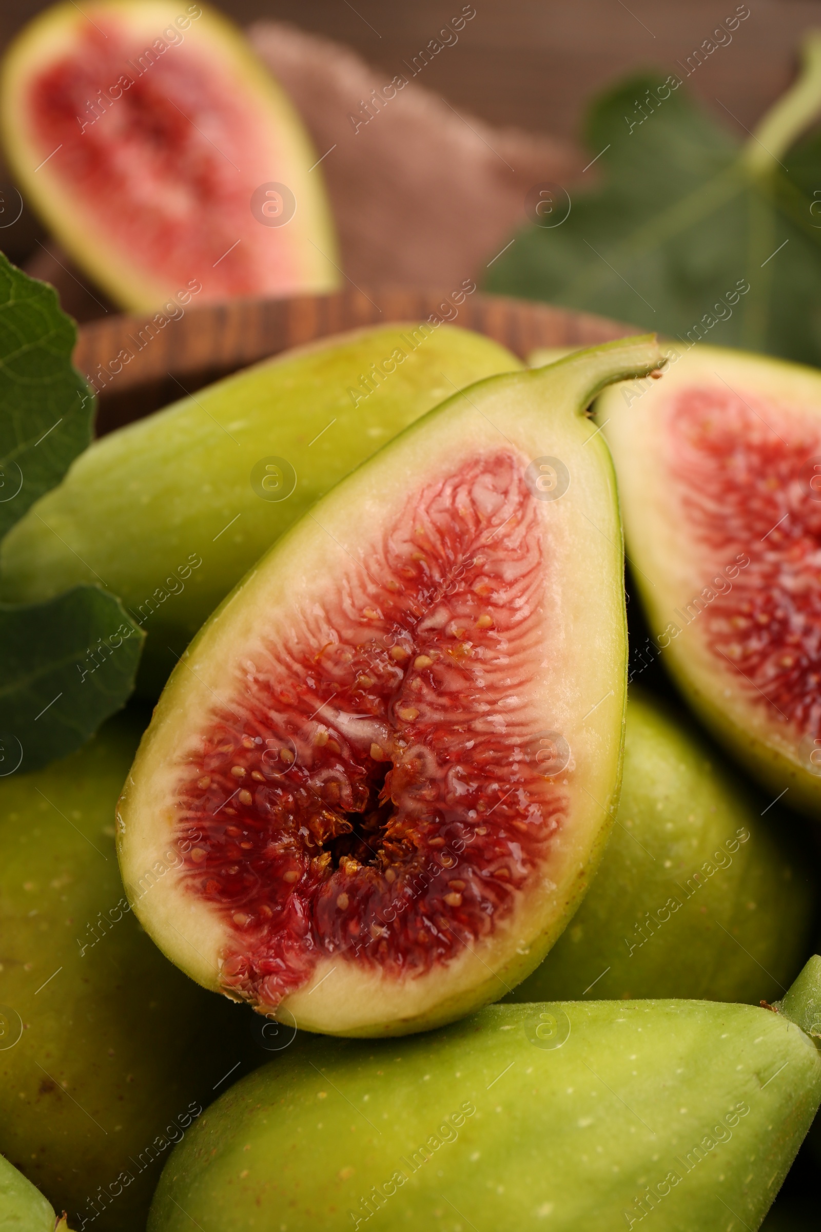 Photo of Cut and whole green figs on table, closeup