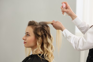 Hair styling. Professional hairdresser working with client indoors, closeup