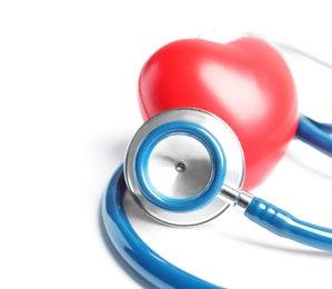 Stethoscope and heart model on light background, closeup. Medical equipment