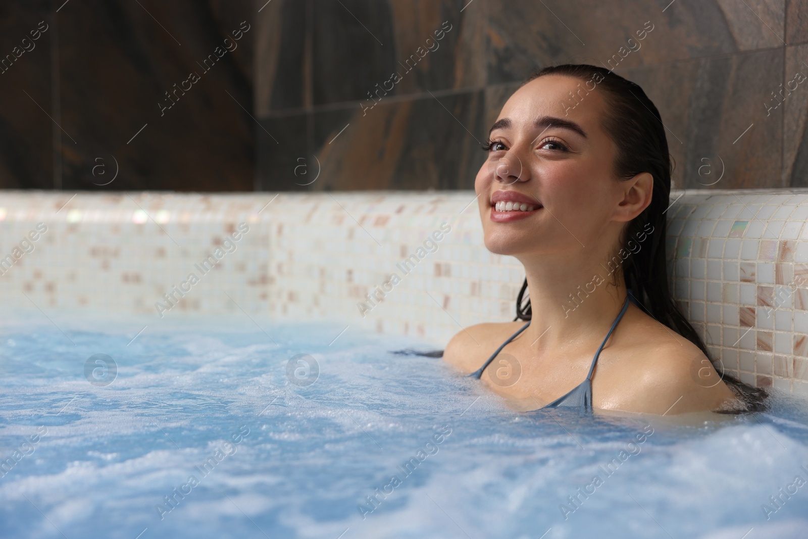 Photo of Beautiful woman relaxing in spa swimming pool, space for text