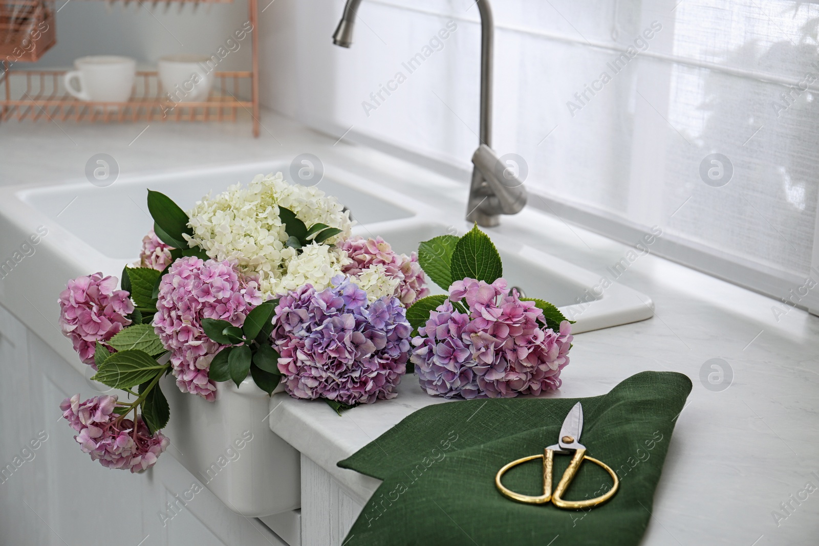 Photo of Bouquet with beautiful hydrangea flowers in sink