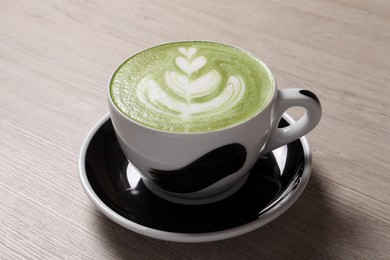 Photo of Cup of fresh matcha latte on wooden table
