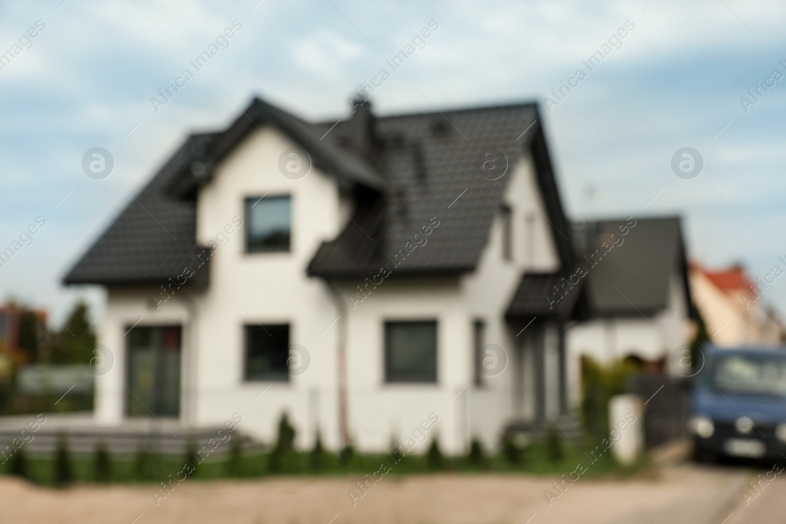 Photo of Blurred view of beautiful house, lovely green lawn and parked car