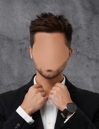 Anonymous. Faceless man in suit near grey wall